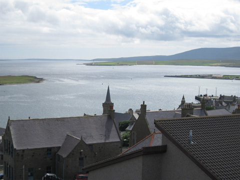 Colour view over rooftops of Stromness across to empty sea and islands beyond.
