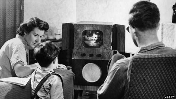 A family watching television at home during the 50s.