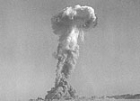 Troops of the Battalion Combat Team, USA Army 11th Airborne Division, watch a plume of radioactive smoke rise after a D-Day blast at Yucca Flats