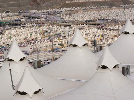 Large area of land covered with white topped marquee tents for miles