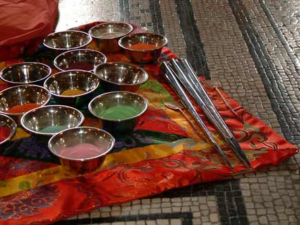 Sand pots on a cushion, with spare chak-pur and grating rods beside them