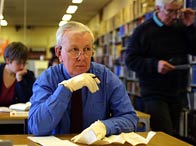 A genealogist researching in a library