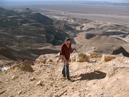 Nicholas Buxton climbs a long, winding rocky path with the Egyptian desert and mountains stretching out below and behind him