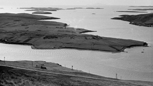 Black and white view looking down at the flat, grassy island of Trondra from the Hill of Easterhoull.