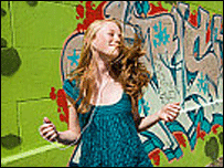 woman dances by graffiti wall